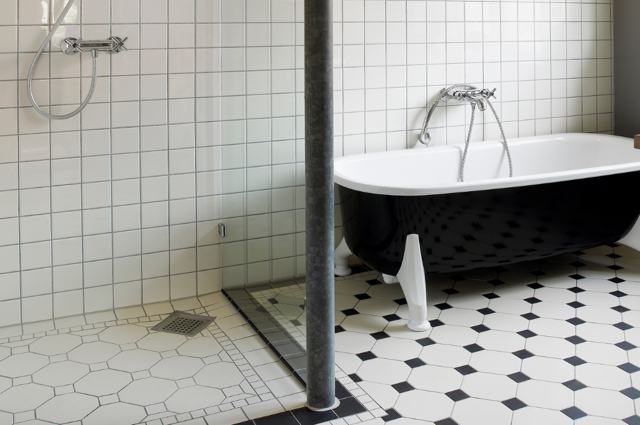 Bagno con rivestimento a parete bianco e pavimento a disegno