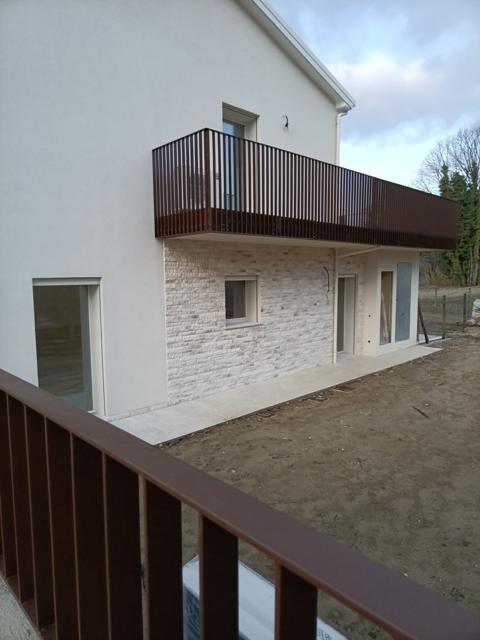 Casa finita con balcone, facciata intonacata e rivestimento in pietra