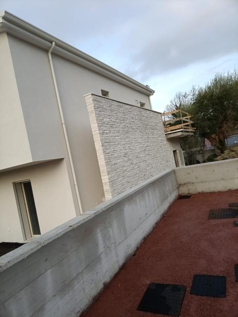Casa intonacata con parete rivestita in pietra